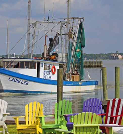 Colorful Chairs with a boat in the background